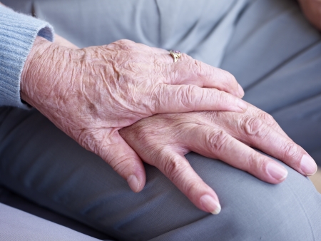 hand of an elderly woman holding the hand of an elderly man の写真素材