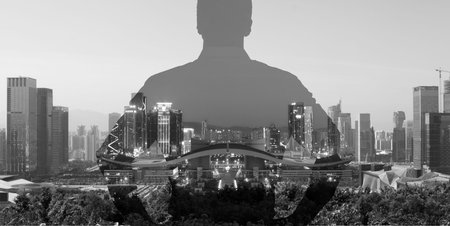 silhouette of a man superimposed on a panorama view of a modern city, black and white.の写真素材
