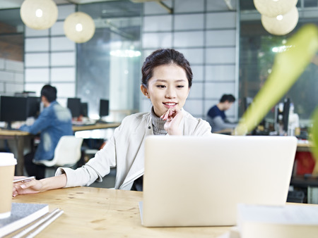 young asian business woman working in office using laptop computer.の写真素材