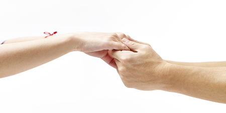 hands of a male and a female held together, isolated on white background.の写真素材