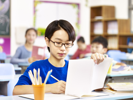 asian primary school student with glasses studying in class.の写真素材