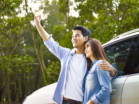 young asian couple taking a selfie during a trip.の写真素材