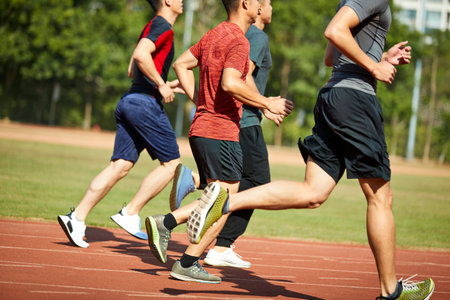 four asian young adults training running on track.の写真素材