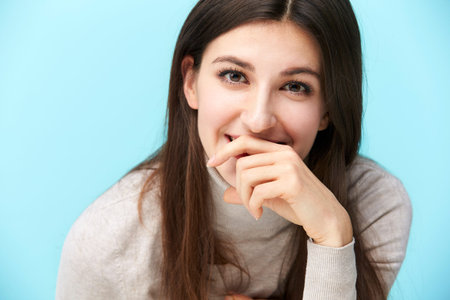 head and shoulder portrait of a young caucasian woman isolated on blue background