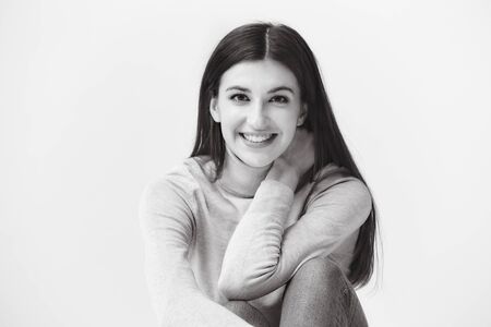 black and white portrait of a beautiful caucasian woman, looking at camera, happy and smilingの写真素材
