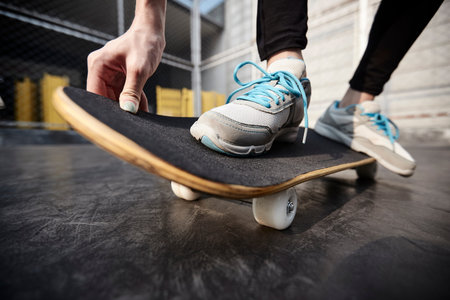 close-up shot of feet of a young asian woman skateboarding outdoors