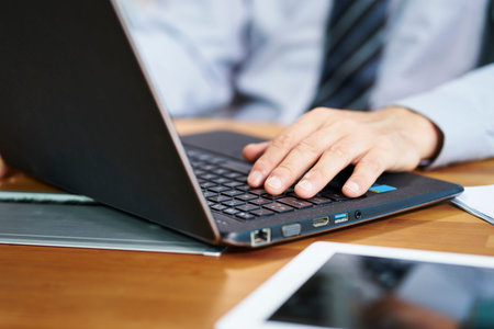 close-up shot of hand of an asian businessman working in office using laptop computer