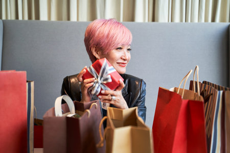 young asian woman sitting in couch relaxing after christmas gifts shopping