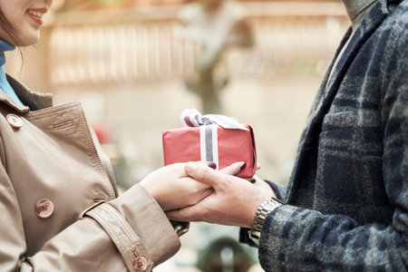 young asian woman ceceiving a christmas or birthday present from husband or boyfriend