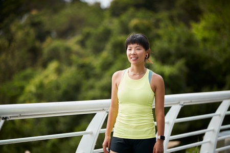 outdoor portrait of a happy young asian woman female athleteの写真素材