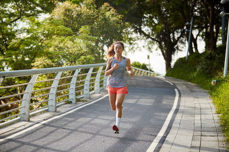 young asian woman running jogging outdoors in park
