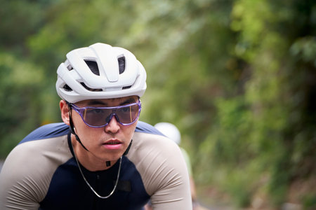young asian man male cyclist riding bike outdoors on rural roadの写真素材