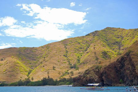 ZAMBALES, PH - MAY 1: Anawangin wooden boat with mountain view on May 1, 2009 in San Antonio, Zambales. Anawangin Cove has a crescent shaped cove with a pristine white sand beach and unusual tall pine-like trees.のeditorial素材
