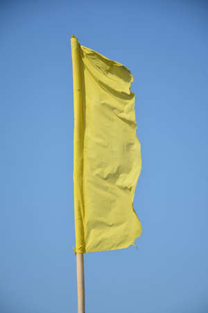 Yellow banner cloth with bamboo pole placed in beach for signal bannerの写真素材