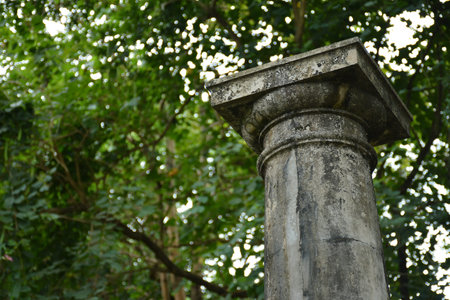 Gray tall Greek inspired beam with art details outside the garden