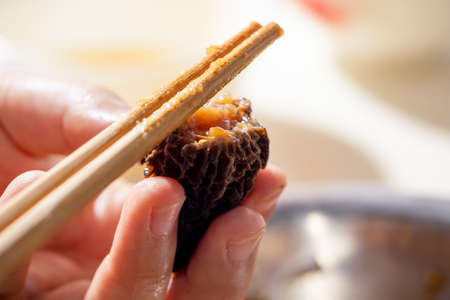 Close-up of woman's hands holding chopsticks and eating.の写真素材