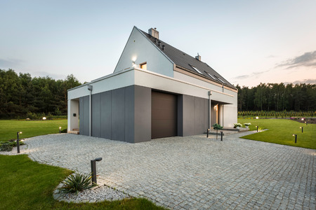 New style white villa with stone driveway, decorative lighting and wide backyardの写真素材