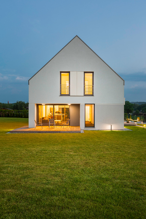 Simple form house located in green landscape, night viewの写真素材