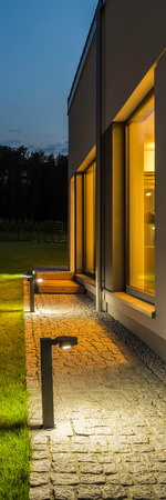 Vertical panorama of new villa with backyard and outdoor lighting, night external viewの写真素材