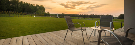 Panoramic view of new villa patio with simple furniture set, sunset viewの写真素材