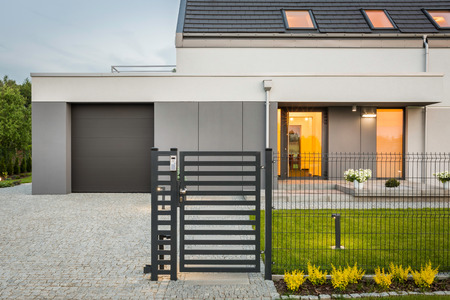 New design villa with decorative fence, garage and stone driveway, external viewの写真素材