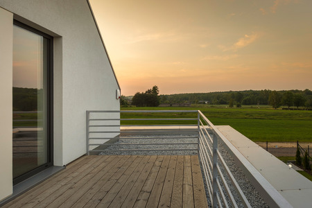 Modern balcony with silver railing and wooden flooringの写真素材
