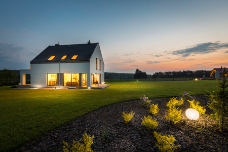 Photo of modern house with outdoor lighting, at night, external view