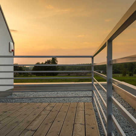 Modern villa terrace with silver railing, wooden floor and amazing viewの写真素材
