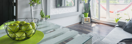 Fresh green apples on table in bright living room, panoramaの写真素材