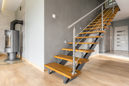 Open floor villa interior with stairs, fireplace in industrial style and wooden floor panelsの写真素材