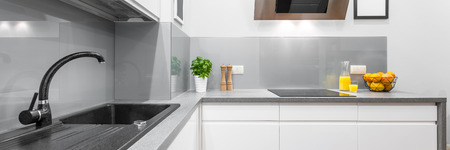 Panorama of stylish kitchen interior in white with granite and solid countertopの写真素材