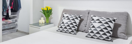 Panorama of new and simple bedroom in grey and white with comfortable double bed
