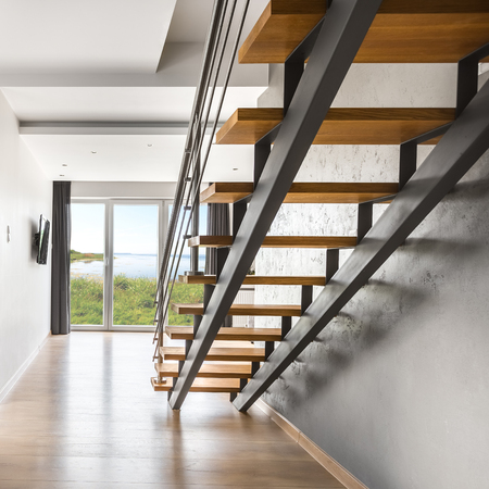 Light villa interior with staircase, balcony doors in the backgroundの写真素材