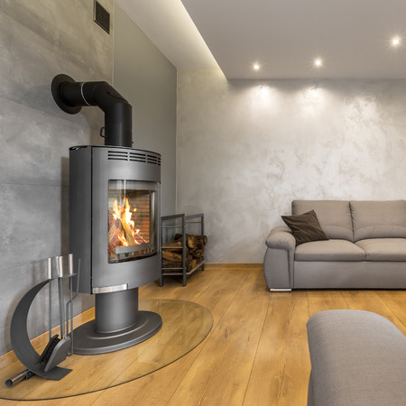 Grey living room with a fireplace, extra large sofa and decorative wall plasterの写真素材