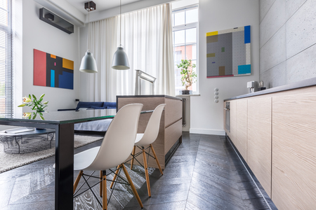 Contemporary kitchen with table, white chairs and grey wall tilesの写真素材