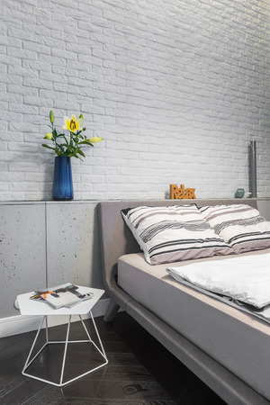 Bedroom with matrimonial bed and white brick wallの写真素材