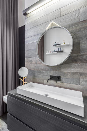 Bathroom with countertop washbasin and wood effect wall tilesの写真素材