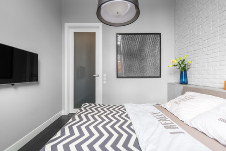 Grey bedroom with tv and double bedの写真素材