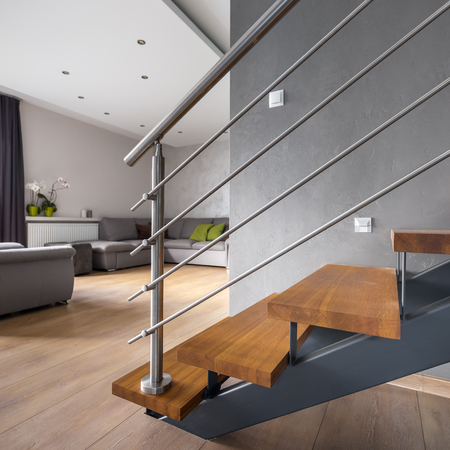 Open floor apartment with wooden staircase and living room の写真素材