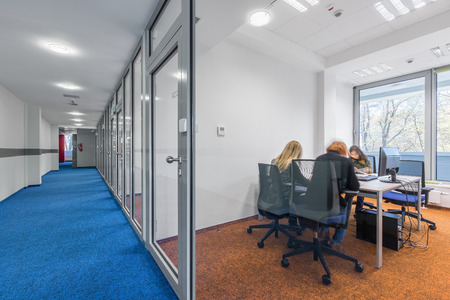 New office interior with glass walls and doors and colorful flooringの写真素材