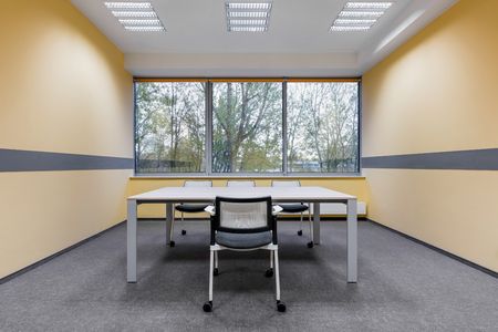 University study room with window, white furniture and yellow wallの写真素材