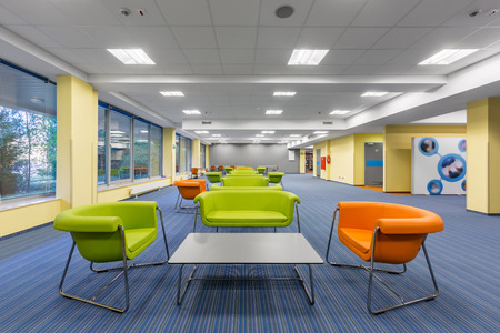 Modern office interior with colorful lounge area, with green and orange furnitureの写真素材