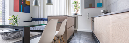Open kitchen with island, table and two white chairs, panoramaの写真素材