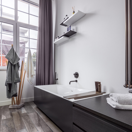 Bright bathroom interior design in industrial style with modern bathtubの写真素材