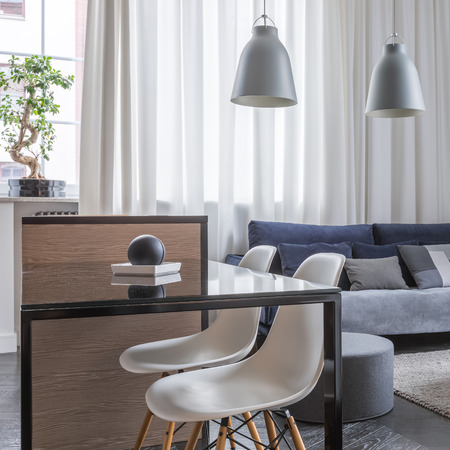 Loft with open living room and kitchen table with white chairsの写真素材