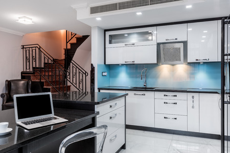 Fancy open kitchen space with laptop on the countertopの写真素材