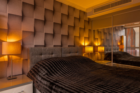 Modern designed bedroom with creative brown 3D wallpaper and big bedの写真素材