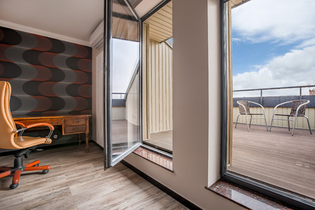 Private home office interior with big windows and exit to the modern balconyの写真素材