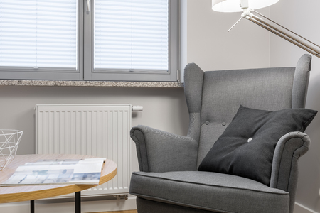 Apartment interior detail, gray armchair and wooden coffee tableの写真素材