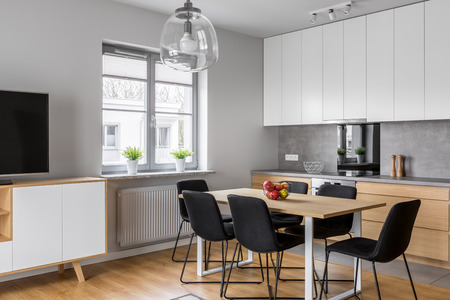 Minimalist, contemporary kitchen with dining room and tv screenの写真素材